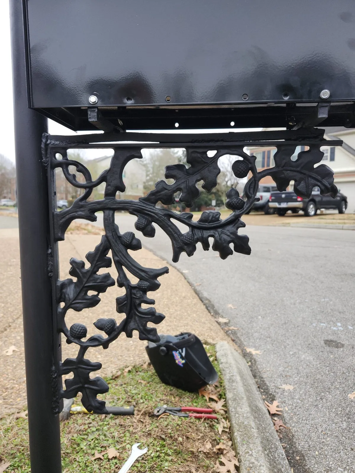 The mailbox post before repair, the cast oak-leaf scrollwork broken loose from the top of the post.