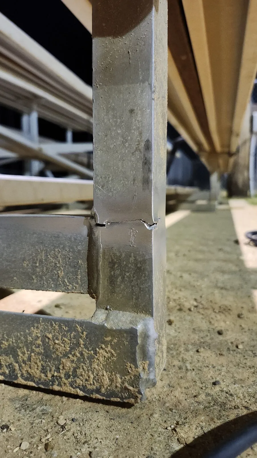 A guardrail post on the rooftop deck cracked clean through just above its base plate.