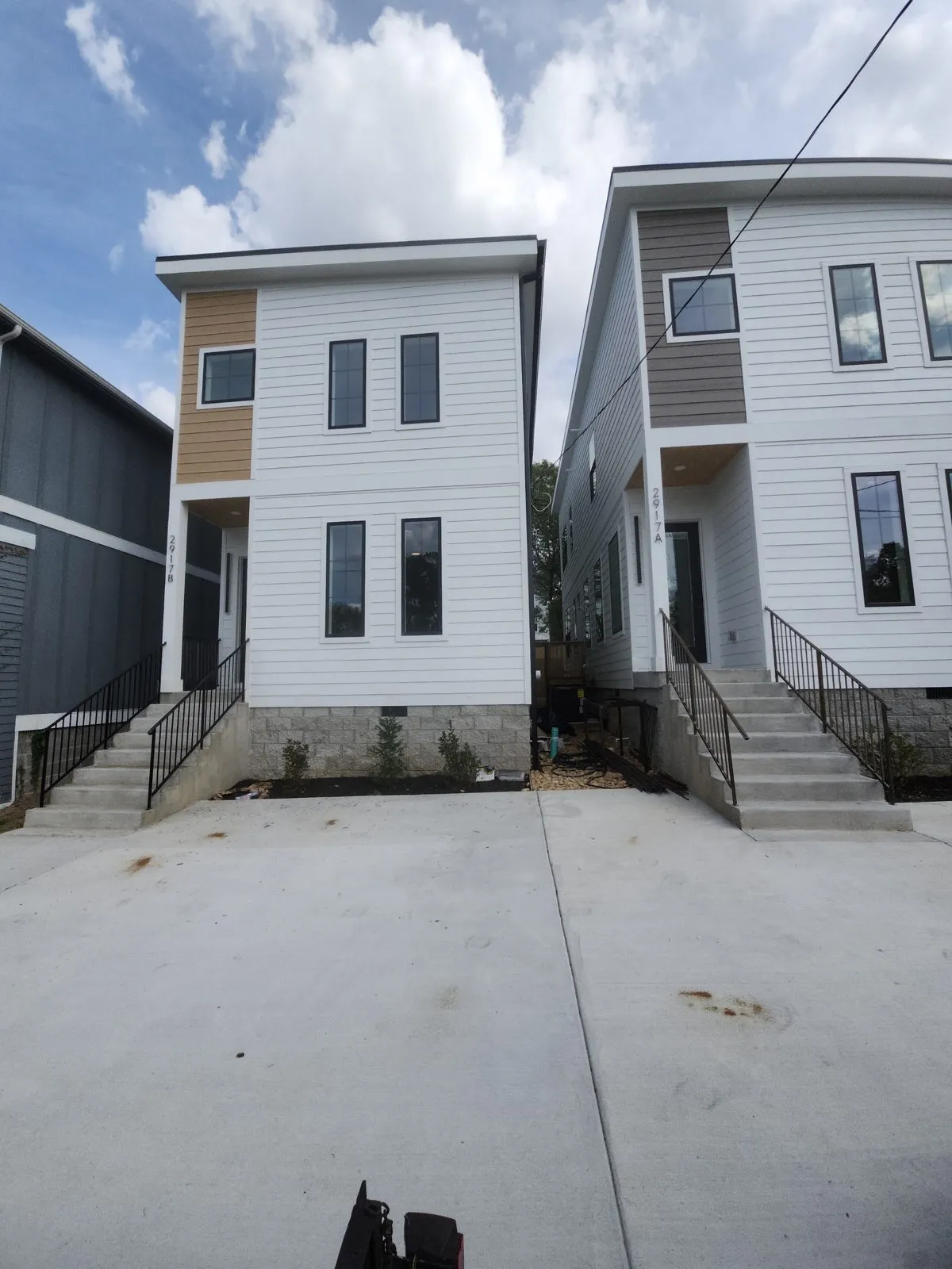 Two townhouse entries with bare concrete steps and no handrails, before installation.